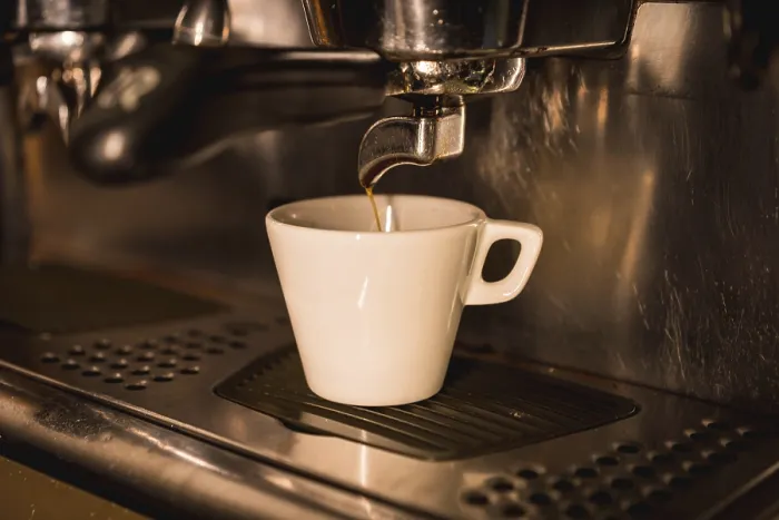 Gerahmter Druck : Kaffeeautomat füllt einen Entkoffeinierten in einen weißen Becher.