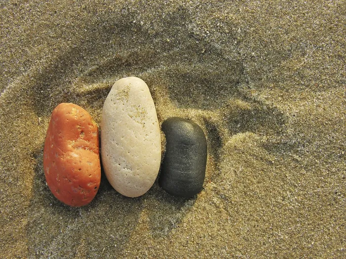 Gerahmter Druck : Farbige Kieselsteine im Sand. Gerahmter Druck : Farbige Kieselsteine im Sand.