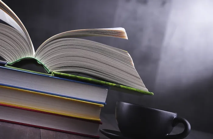 Gerahmter Druck : Komposition mit Büchern und Kaffeetasse auf dem Tisch.