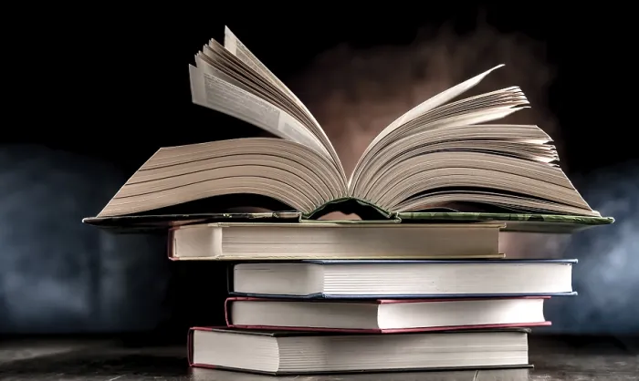 Gerahmter Druck : Eine Komposition mit einem offenen Buch, das auf einem Stapel anderer Bücher liegt. Gerahmter Druck : Eine Komposition mit einem offenen Buch, das auf einem Stapel anderer Bücher liegt.