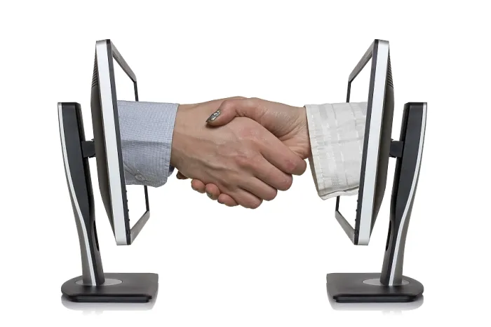 Gerahmter Druck : Zwei Computer-Monitore und Hände beim Handshake. Gerahmter Druck : Zwei Computer-Monitore und Hände beim Handshake.