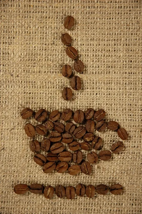 Gerahmter Druck : Konzeptionelles künstlerisches Muster eines Kaffeebechers aus Kaffebohnen auf einem Sackleinens-Hintergrund. Gerahmter Druck : Konzeptionelles künstlerisches Muster eines Kaffeebechers aus Kaffebohnen auf einem Sackleinens-Hintergrund.