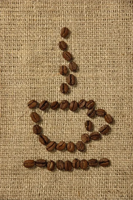 Gerahmter Druck : Konzeptionelles künstlerisches Muster eines Kaffeebechers aus Kaffeebohnen auf einem Sackleinens-Hintergrund. Gerahmter Druck : Konzeptionelles künstlerisches Muster eines Kaffeebechers aus Kaffeebohnen auf einem Sackleinens-Hintergrund.