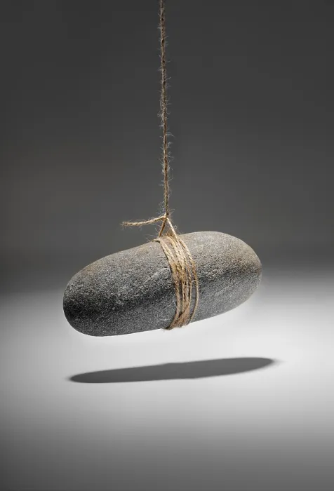 Gerahmter Druck : Konzeptionelle Abbildung eines kleinen Felsens, der an einer Schnur hängt. Gerahmter Druck : Konzeptionelle Abbildung eines kleinen Felsens, der an einer Schnur hängt.
