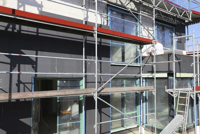 Gerahmter Druck : Bauarbeiter isolieren eine Hausfassade. Gerahmter Druck : Bauarbeiter isolieren eine Hausfassade.