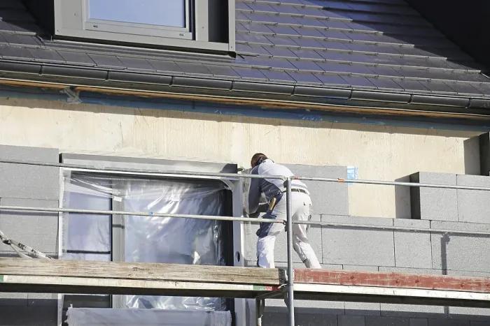Gerahmter Druck : Bauarbeiter isolieren ein Hausfassade Gerahmter Druck : Bauarbeiter isolieren ein Hausfassade