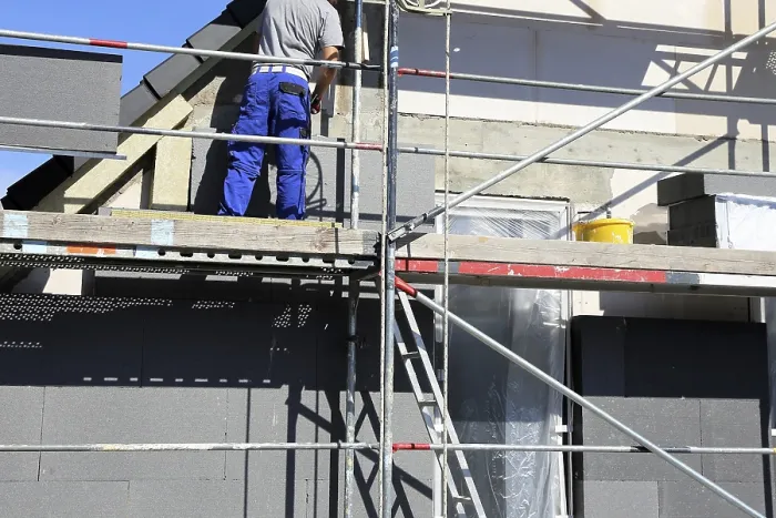 Gerahmter Druck : Bauarbeiter isolieren ein Hausfassade Gerahmter Druck : Bauarbeiter isolieren ein Hausfassade