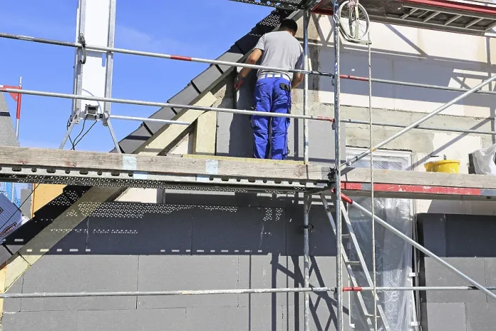 Gerahmter Druck : Bauarbeiter isolieren eine Hausfassade. Gerahmter Druck : Bauarbeiter isolieren eine Hausfassade.