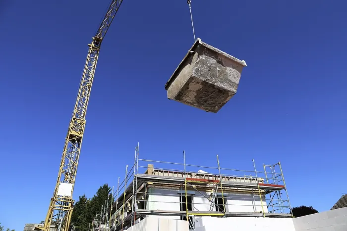 Gerahmter Druck : Ein Behälter für den Abfall von Bauabfällen wird auf einem Baustellen platziert. Gerahmter Druck : Ein Behälter für den Abfall von Bauabfällen wird auf einem Baustellen platziert.