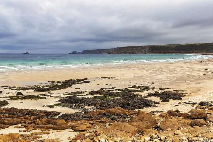 Gerahmter Druck : Bucht mit Felsen und Sandstrand.