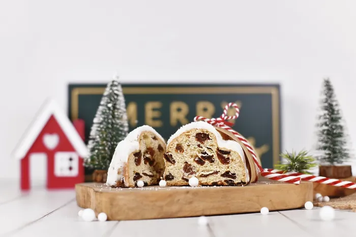 Gerahmter Druck : Schneide den deutschen Stollenkuchen, ein Obstbrot mit Nüssen, auf. Gerahmter Druck : Schneide den deutschen Stollenkuchen, ein Obstbrot mit Nüssen, auf.