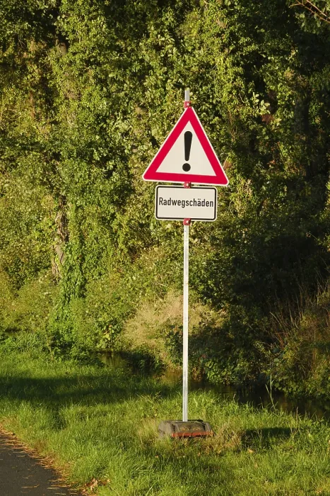 Gerahmter Druck : Radwegschäden, Verkehrsschild. Gerahmter Druck : Radwegschäden, Verkehrsschild.
