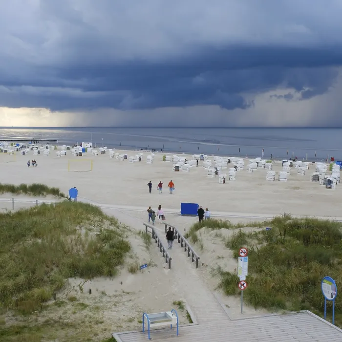 Gerahmter Druck : Dunkle Wolken über dem Nordsee, Strandkörbe und Touristen auf der Sandstrand in Norddeich, Norden, Nordsee, Niedersachsen. Gerahmter Druck : Dunkle Wolken über dem Nordsee, Strandkörbe und Touristen auf der Sandstrand in Norddeich, Norden, Nordsee, Niedersachsen.