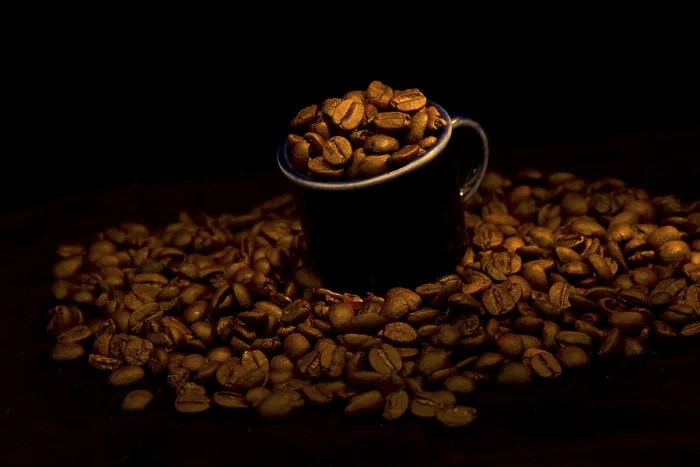 Gerahmter Druck : Dunkler kleiner Becher mit Kaffeebohnen. Gerahmter Druck : Dunkler kleiner Becher mit Kaffeebohnen.