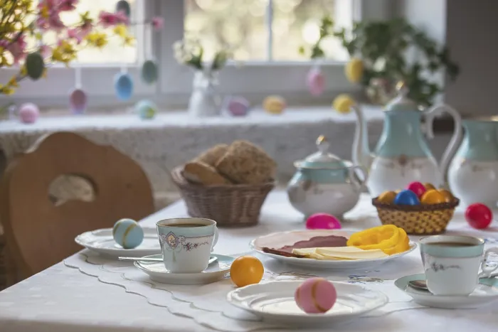 Gerahmter Druck : Gedeckter Tisch mit farbenfrohen Ostereiern.