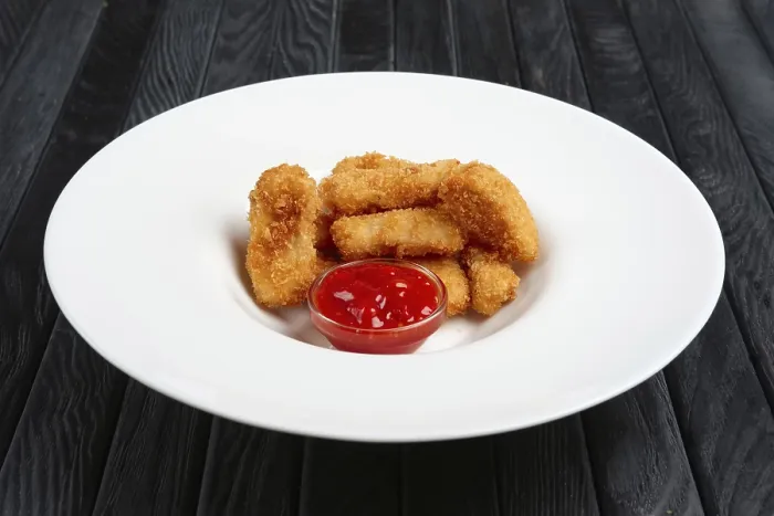 Gerahmter Druck : Frittierte Hähnchenstücke auf einem Teller. Gerahmter Druck : Frittierte Hähnchenstücke auf einem Teller.
