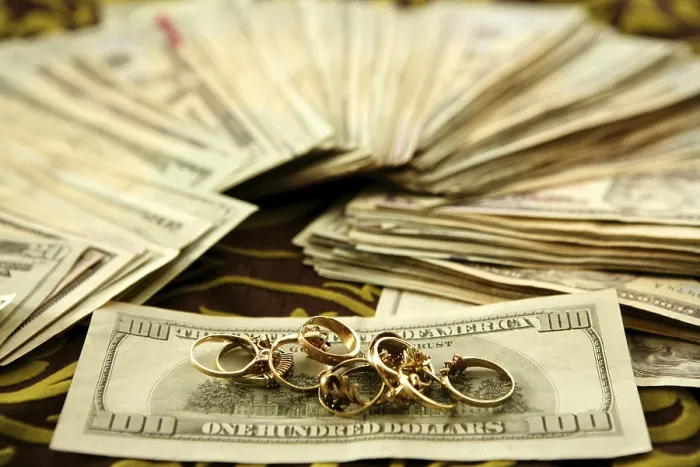 Gerahmter Druck : Dollar-Scheine und Goldringe über Tischdecke. Gerahmter Druck : Dollar-Scheine und Goldringe über Tischdecke.