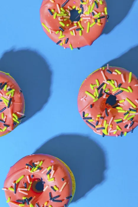 Gerahmter Druck : Donuts auf blauer Hintergrund mit rosa Glasur. Gerahmter Druck : Donuts auf blauer Hintergrund mit rosa Glasur.