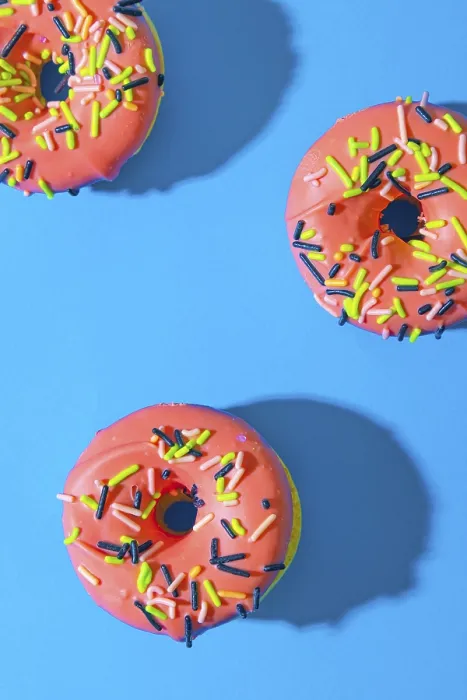 Gerahmter Druck : Donuts auf blauer Hintergrund mit rosa Glaze. Gerahmter Druck : Donuts auf blauer Hintergrund mit rosa Glaze.
