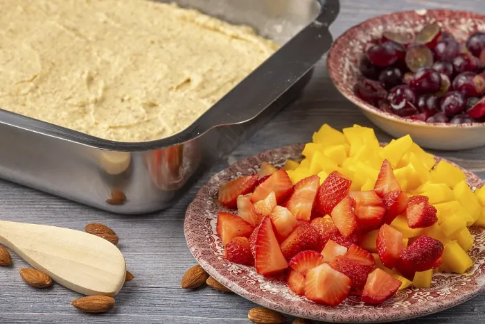 Gerahmter Druck : Teig in einem Formen neben geschnittenem Obst. Gerahmter Druck : Teig in einem Formen neben geschnittenem Obst.