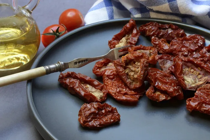 Gerahmter Druck : Trockene Tomaten auf Teller mit Gabel. Gerahmter Druck : Trockene Tomaten auf Teller mit Gabel.