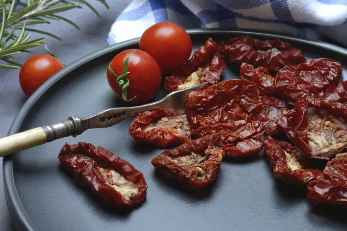 Gerahmter Druck : Trockene Tomaten auf Teller mit Gabel. Gerahmter Druck : Trockene Tomaten auf Teller mit Gabel.