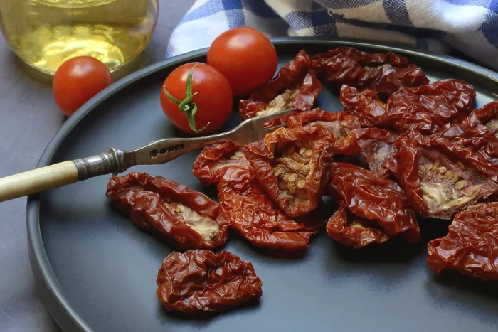 Gerahmter Druck : Trockene Tomaten auf Teller mit Gabel. Gerahmter Druck : Trockene Tomaten auf Teller mit Gabel.