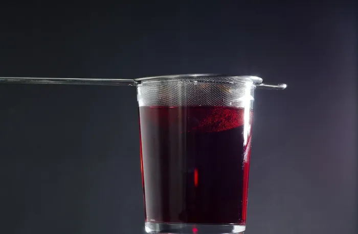 Gerahmter Druck : Trinkglas mit Sieb für roten Tee. Gerahmter Druck : Trinkglas mit Sieb für roten Tee.