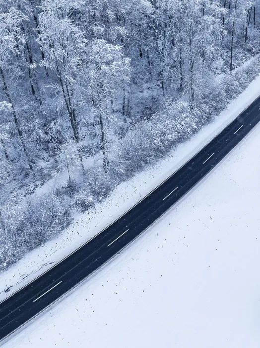Gerahmter Druck : Bild eines Drohnen über eine Straße, die von Schnee umgeben ist in einer winterlichen Umgebung. Gerahmter Druck : Bild eines Drohnen über eine Straße, die von Schnee umgeben ist in einer winterlichen Umgebung.