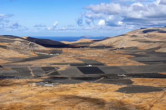 Gerahmter Druck : Trockener vulkanischer Landschaft mit Feldern.