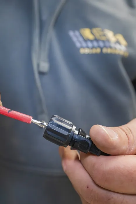 Gerahmter Druck : Elektriker sitzt mit Kabelstecker in der Hand. Gerahmter Druck : Elektriker sitzt mit Kabelstecker in der Hand.