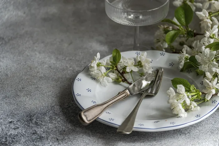 Gerahmter Druck : Eleganter Tischservice mit einem weißen Teller, der feine florale Muster aufweist. Gerahmter Druck : Eleganter Tischservice mit einem weißen Teller, der feine florale Muster aufweist.