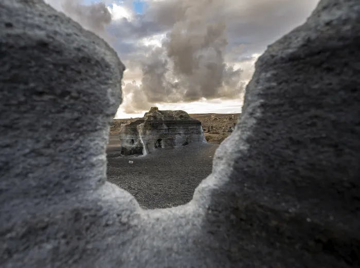 Gerahmter Druck : Erosionsschuttformationen, vulkanische Landschaft mit dramatischem wolkenverhangenen Himmel bei Sonnenuntergang. Gerahmter Druck : Erosionsschuttformationen, vulkanische Landschaft mit dramatischem wolkenverhangenen Himmel bei Sonnenuntergang.