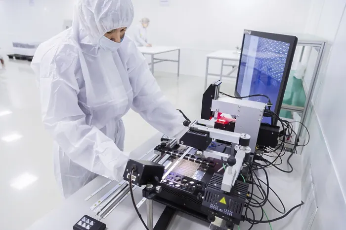 Gerahmter Druck : Ein Fabrikarbeiter in einem weißen Laboranzug.