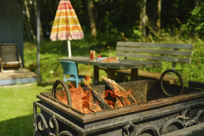 Gerahmter Druck : Feuerkorb verbrennt Holz in einem Außenbereich. Gerahmter Druck : Feuerkorb verbrennt Holz in einem Außenbereich.