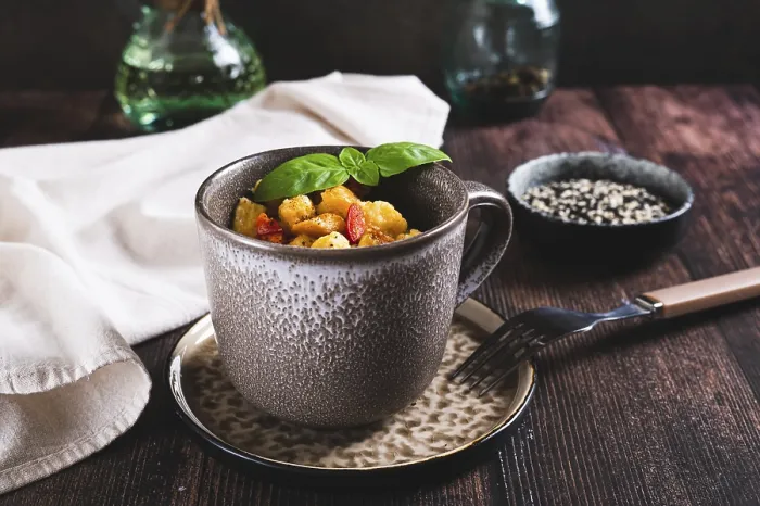 Gerahmter Druck : Lebensmittel, Brot pudding mit Ei, Pfeffer und Basilikum in einem Becher auf dem Tisch. Gerahmter Druck : Lebensmittel, Brot pudding mit Ei, Pfeffer und Basilikum in einem Becher auf dem Tisch.