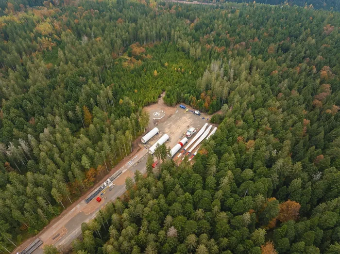 Gerahmter Druck : Wald mit Baustelle, an der Windenergiekomponenten gelagert sind. Gerahmter Druck : Wald mit Baustelle, an der Windenergiekomponenten gelagert sind.