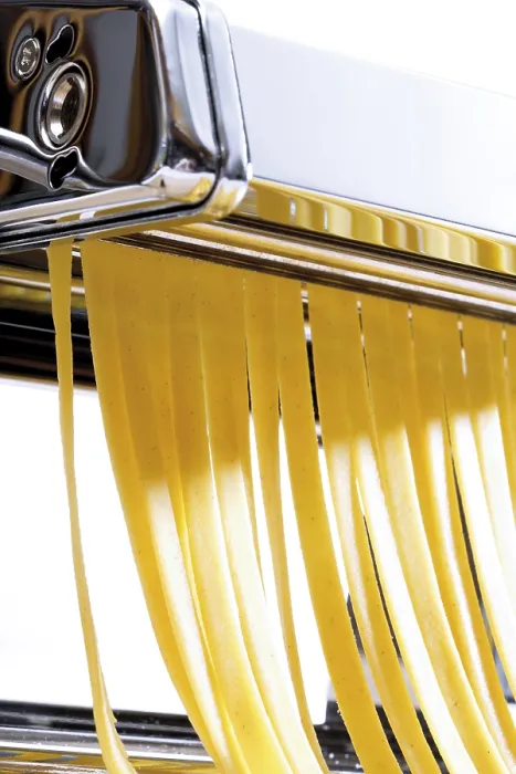 Gerahmter Druck : Frische Pasta, die mit einem Pasta-Macher hergestellt wird. Gerahmter Druck : Frische Pasta, die mit einem Pasta-Macher hergestellt wird.