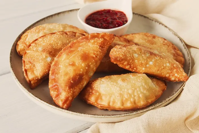 Gerahmter Druck : Frittierte Chebureks, Nahsicht, auf hellen Hintergrund. Gerahmter Druck : Frittierte Chebureks, Nahsicht, auf hellen Hintergrund.