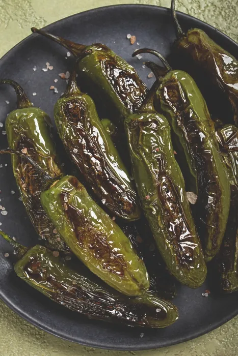 Gerahmter Druck : Gepökelte Padron-Paprika, in einer Pfanne. Gerahmter Druck : Gepökelte Padron-Paprika, in einer Pfanne.