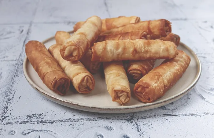 Gerahmter Druck : Frittierter Käse-Springroll auf einem Teller mit Sahne-Sauce. Gerahmter Druck : Frittierter Käse-Springroll auf einem Teller mit Sahne-Sauce.