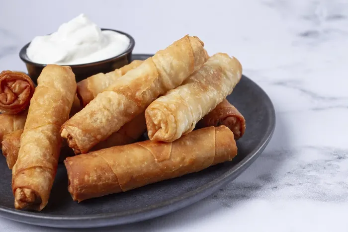 Gerahmter Druck : Frittierte Springrollen mit Käse auf einem Teller mit Sahnesauce Gerahmter Druck : Frittierte Springrollen mit Käse auf einem Teller mit Sahnesauce