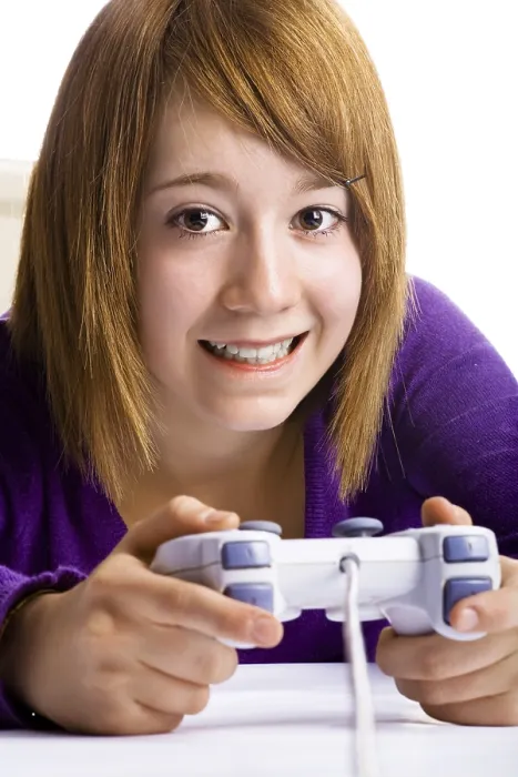Gerahmter Druck : Mädchen mit einem Spielcontroller, das ein Computerspiel spielt. Gerahmter Druck : Mädchen mit einem Spielcontroller, das ein Computerspiel spielt.
