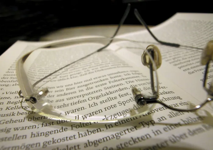 Gerahmter Druck : Brille und Buch.