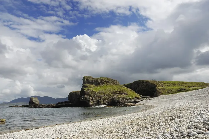 Gerahmter Druck : Kalksteinfelsen mit Gras auf einem breiten Kiesstrand. Gerahmter Druck : Kalksteinfelsen mit Gras auf einem breiten Kiesstrand.