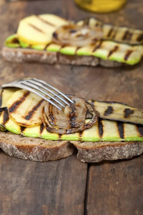 Gerahmter Druck : Gegrillte Gemüse auf rustikalem Brot über einem Holztisch. Gerahmter Druck : Gegrillte Gemüse auf rustikalem Brot über einem Holztisch.