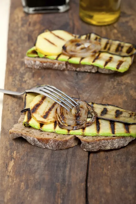 Gerahmter Druck : Gegrillte Gemüse auf rustikalem Brot über einem Holztisch. Gerahmter Druck : Gegrillte Gemüse auf rustikalem Brot über einem Holztisch.