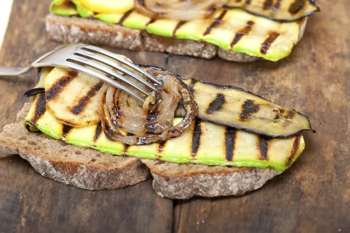 Gerahmter Druck : Gegrillte Gemüse auf rustikalem Brot über einem Holztisch. Gerahmter Druck : Gegrillte Gemüse auf rustikalem Brot über einem Holztisch.
