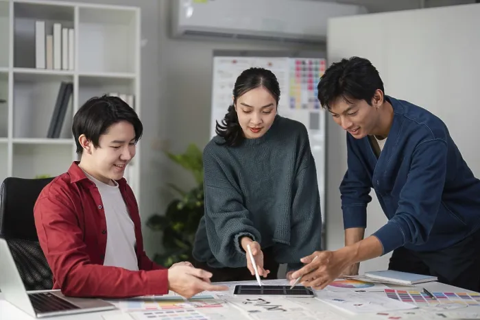 Gerahmter Druck : Ein Team von Designern brütet aus, während sie Farbselektionen und Mock-ups analysieren. Gerahmter Druck : Ein Team von Designern brütet aus, während sie Farbselektionen und Mock-ups analysieren.