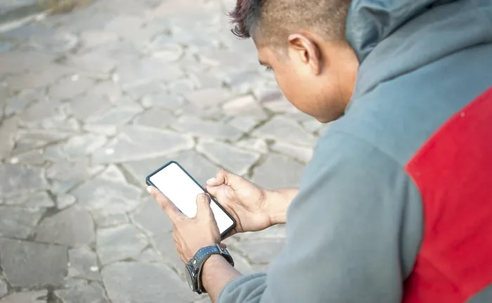 Gerahmter Druck : Ein Mann sitzt mit seinem Mobiltelefon. Gerahmter Druck : Ein Mann sitzt mit seinem Mobiltelefon.
